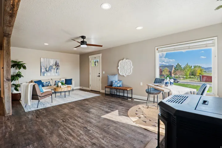 Open concept living space featuring wood-finish flooring, recessed lighting, and a prominent picture window