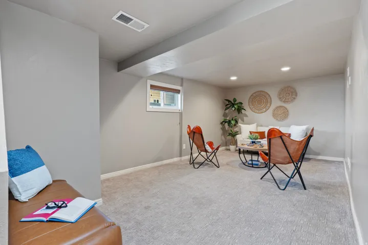 Carpeted room with recessed lighting and a window featuring wood-finish blinds