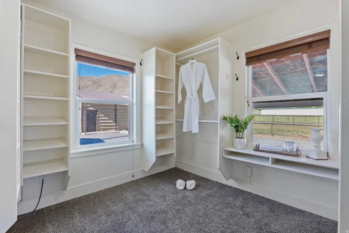 Built-in shelving and hanging storage around two windows with mountain scenery