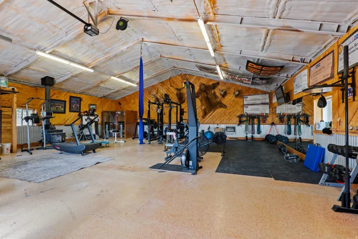 Spacious multi-purpose room featuring wood-paneled walls and a vaulted ceiling