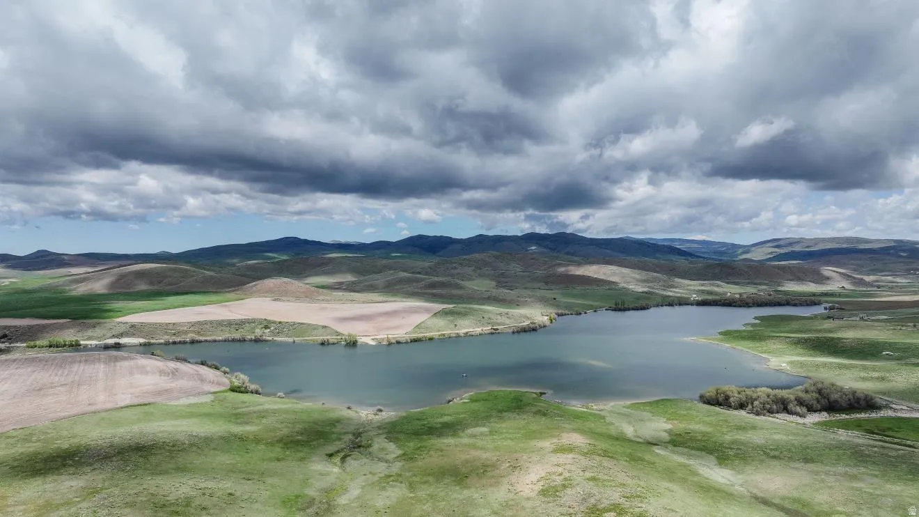 Expansive land featuring a large lake and rolling hills