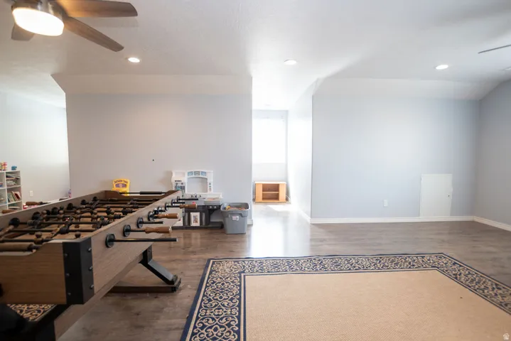 Spacious room featuring wood-finish flooring, recessed lighting, and a ceiling fan