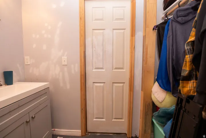 Six-panel door with wood-finish trim, complemented by a vanity with shaker-style cabinetry and a sink with a chrome faucet