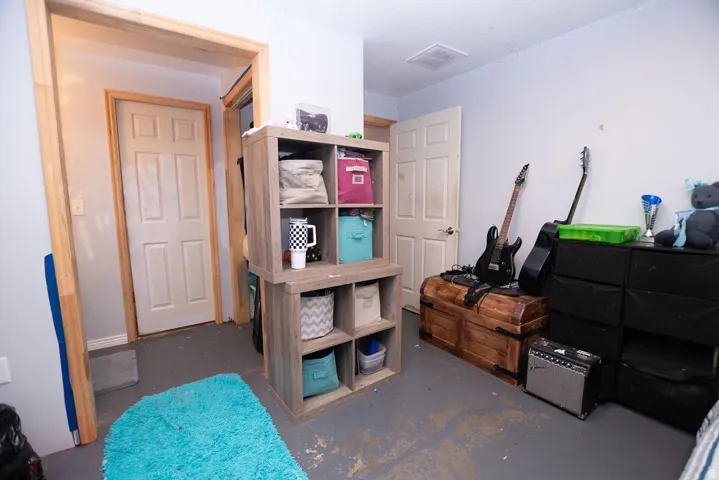 Room featuring light gray walls, gray flooring, and white paneled doors