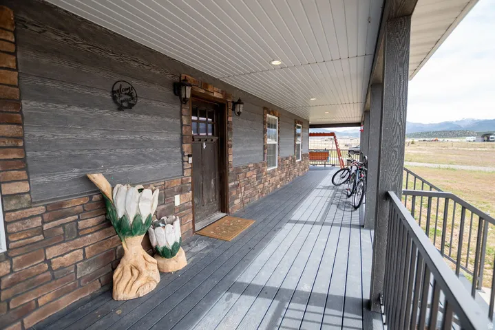 Covered porch featuring durable composite decking and a sturdy metal railing
