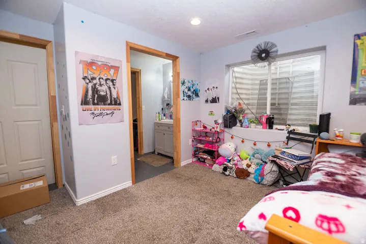 Carpeted room with a window well, light gray walls, and recessed lighting