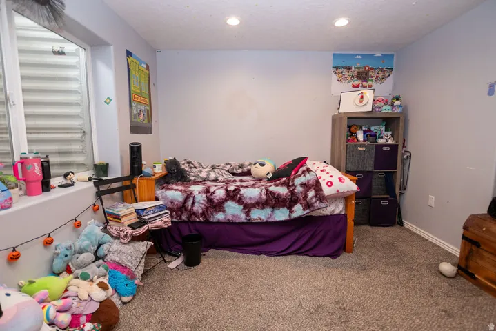 Carpeted room featuring a window well, light gray walls, white trim, and recessed lighting