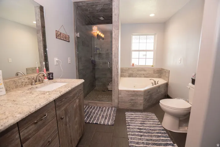 Bathroom featuring a vanity with a light-colored countertop, an undermount sink, and wood-finish cabinetry