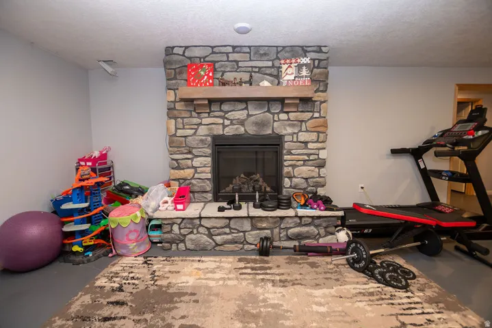 Stone-clad fireplace featuring a hearth, wood mantle, and an enclosed firebox