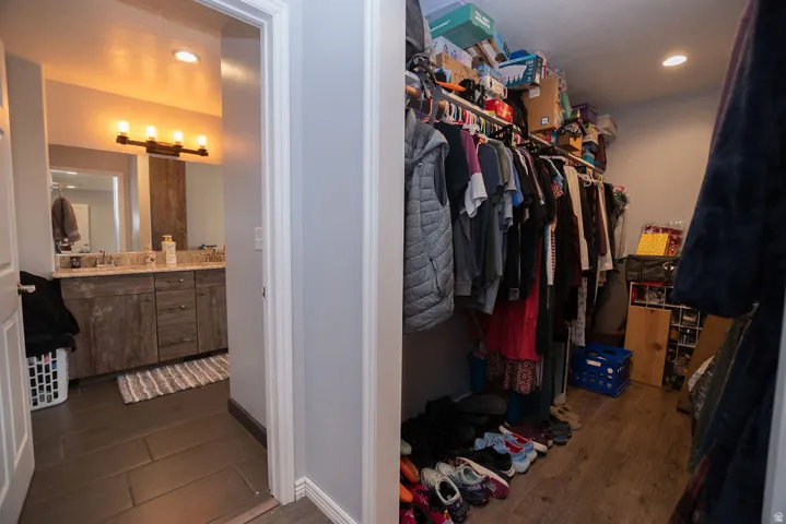 Walk-in closet with wood-finish flooring and integrated shelving
