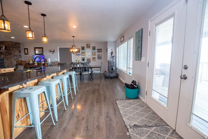 Spacious open-concept interior featuring wood-finish flooring, a stone-accented wall, and multiple windows