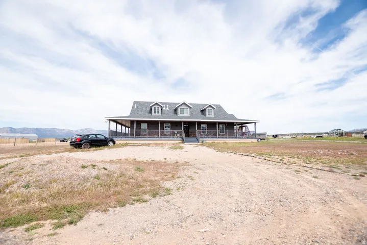 Ranch-style residence featuring a broad covered front porch with a swing and multiple dormer windows