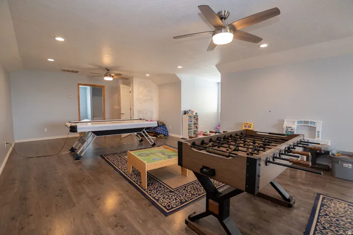 Spacious bonus room featuring wood-finish flooring, recessed lighting, and two ceiling fans with integrated lighting
