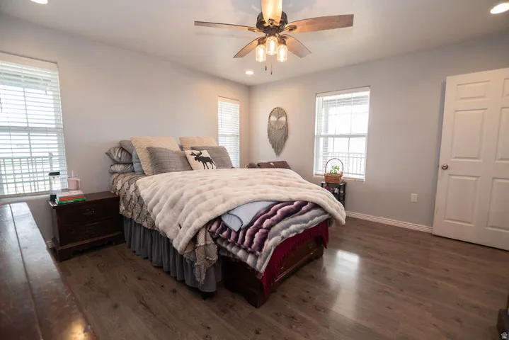 Room featuring wood-finish flooring, light grey walls, and white trim