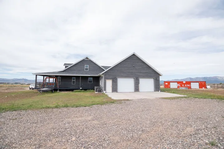 Dark gray exterior siding with white garage doors