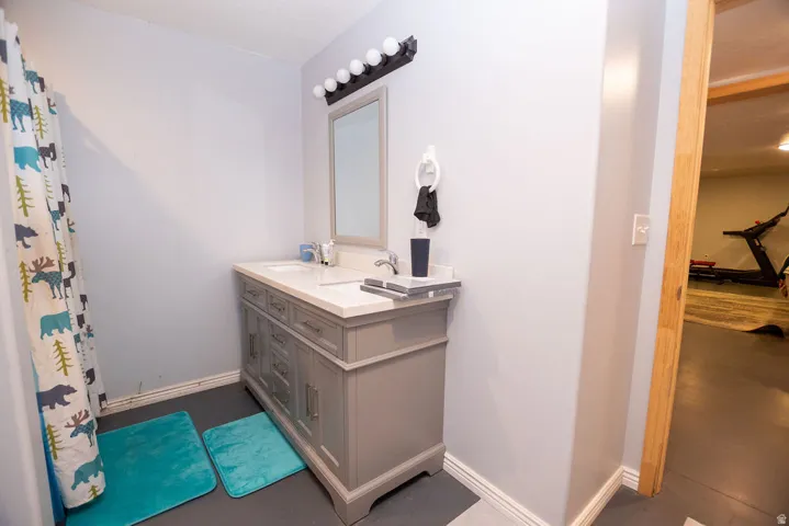 Bathroom featuring a double vanity with light gray cabinetry, a white countertop, and dual integrated sinks
