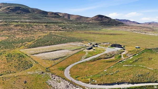 Expansive property featuring a single-story residence, multiple outbuildings, and a winding driveway