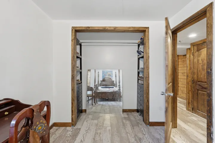Wood-finish flooring throughout, complemented by white walls and exposed wood door frames