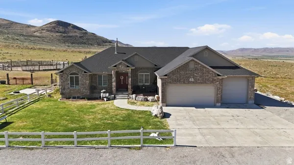 Ranch-style residence featuring a stone and brick facade, a two-car garage, and a concrete driveway