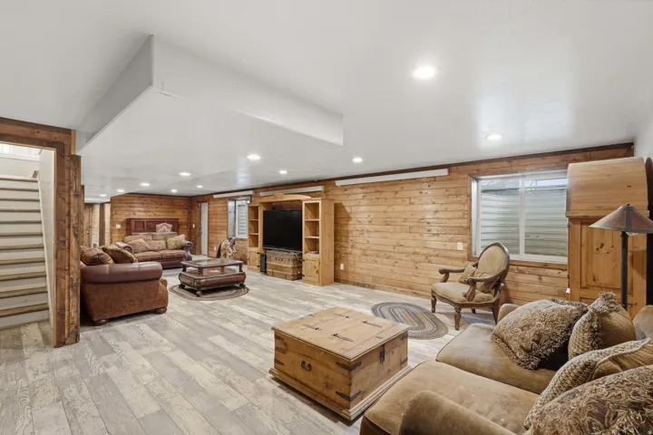 Spacious lower level featuring wood-finish flooring, recessed lighting, and natural wood plank wall finishes
