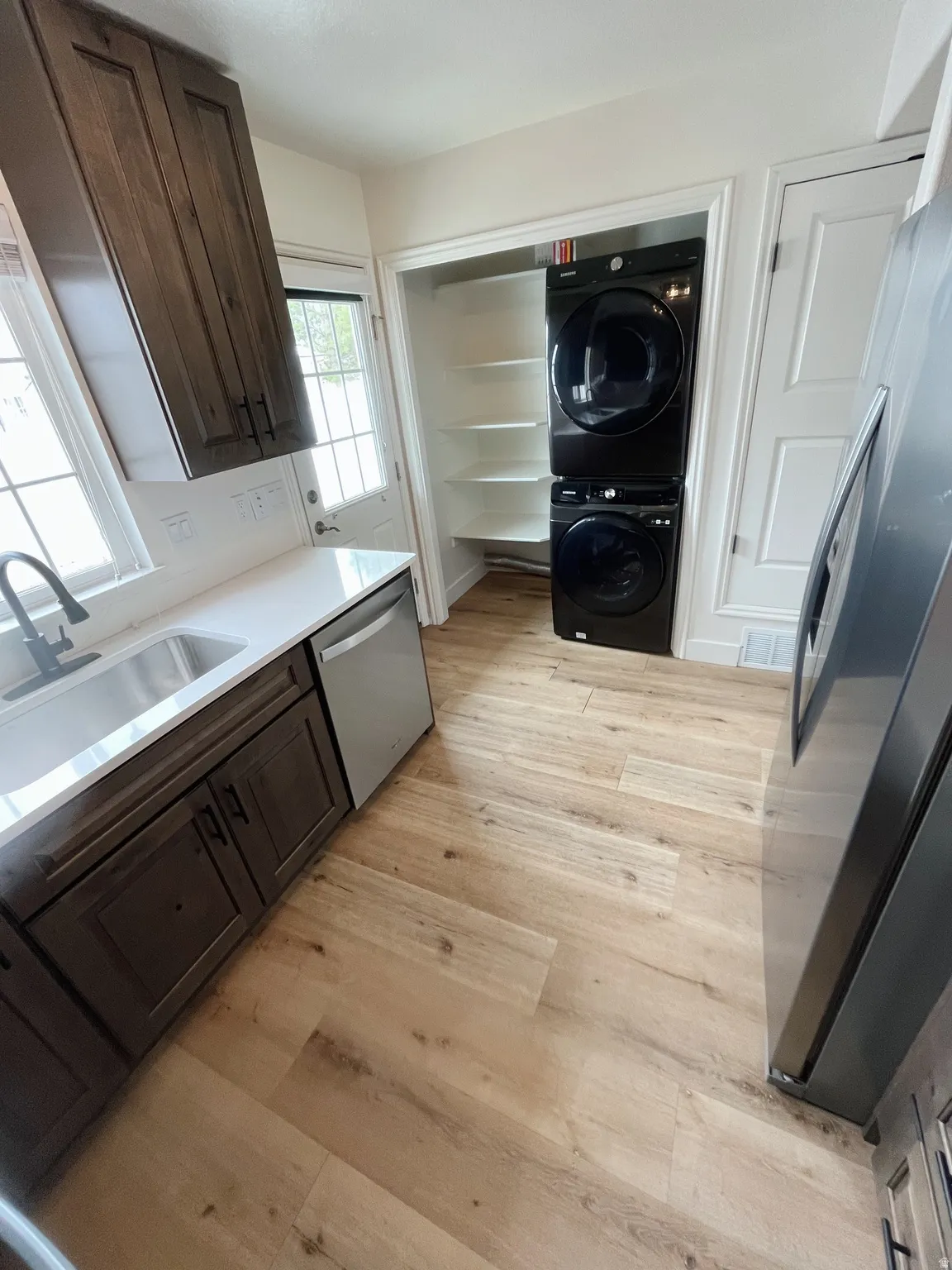 Light wood-finish flooring complements dark wood cabinetry and white countertops