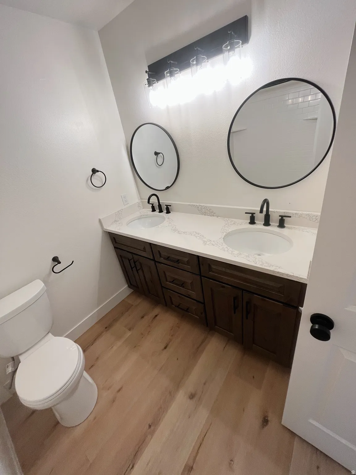 Double vanity with dark wood cabinetry, white countertops, and dual undermount sinks