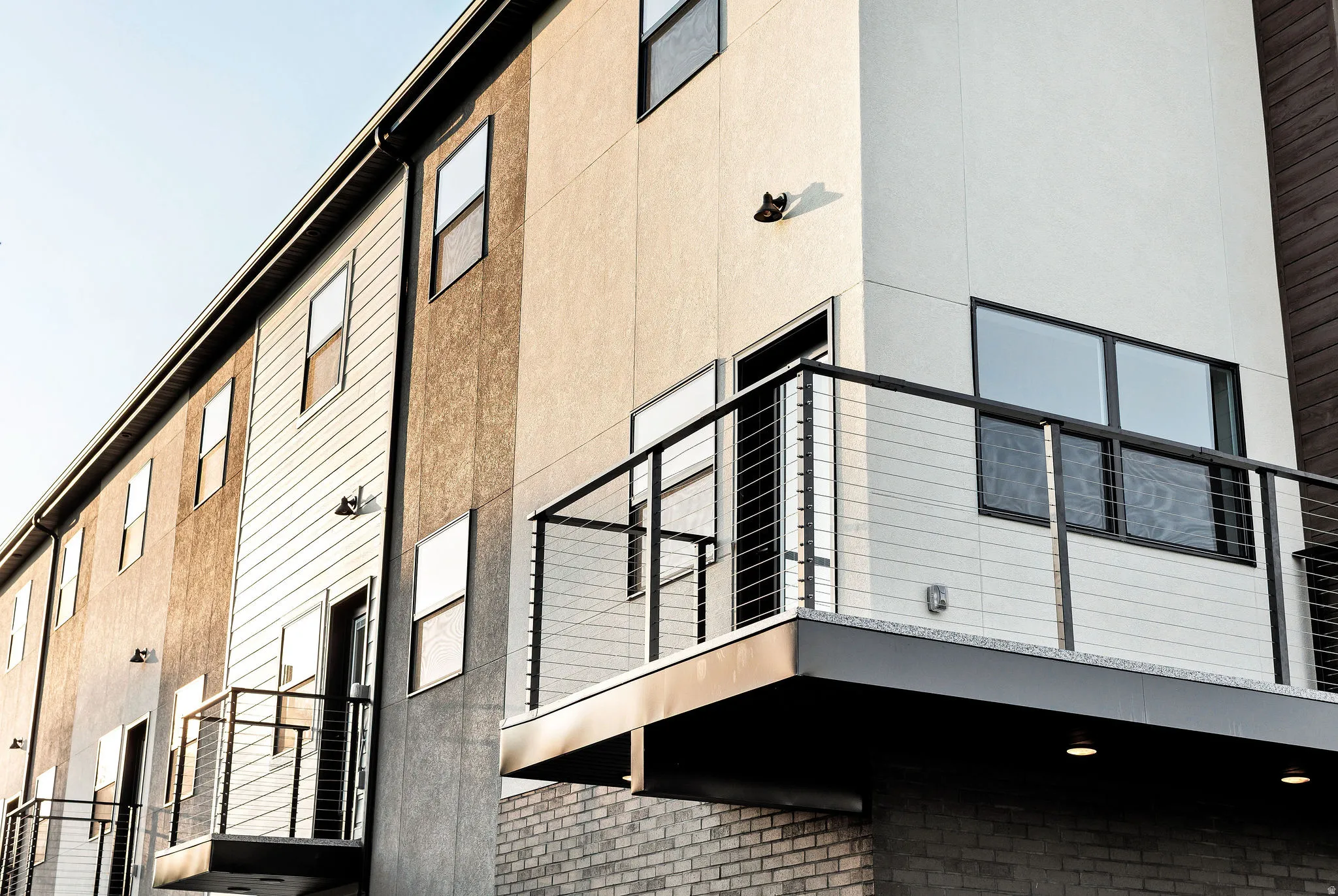 Modern multi-story exterior with varied facade materials including stucco and horizontal siding