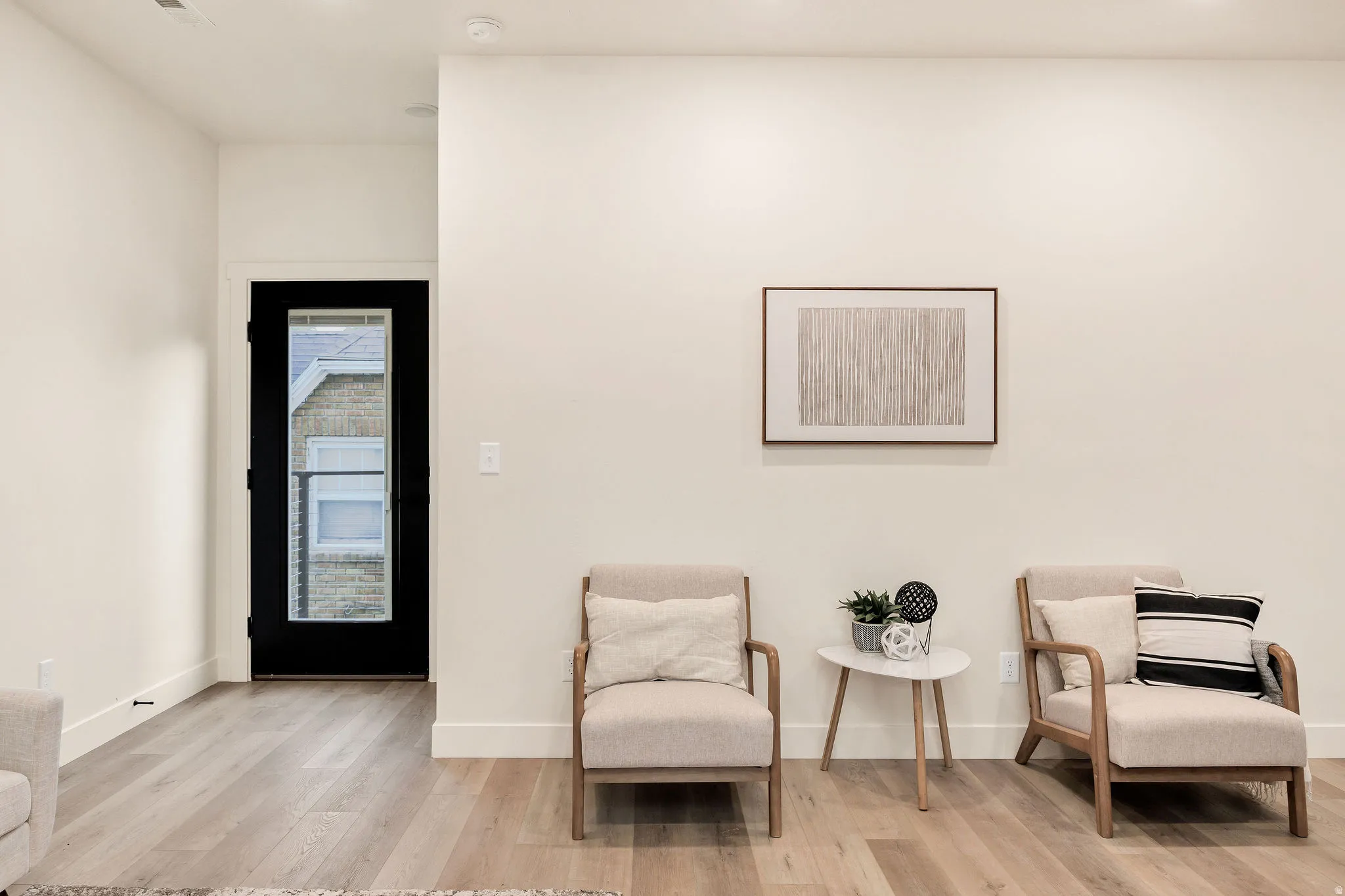 Full-light panel door with dark trim, recessed lighting, and wood-finish flooring