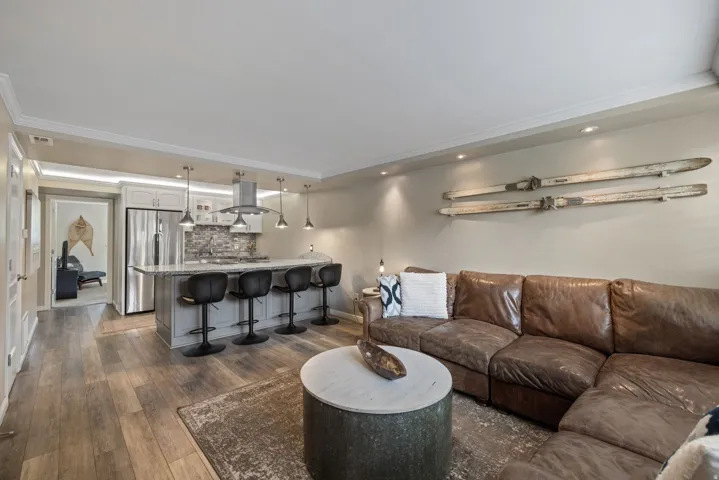Open concept living area featuring wood-finish flooring, recessed lighting, and crown molding