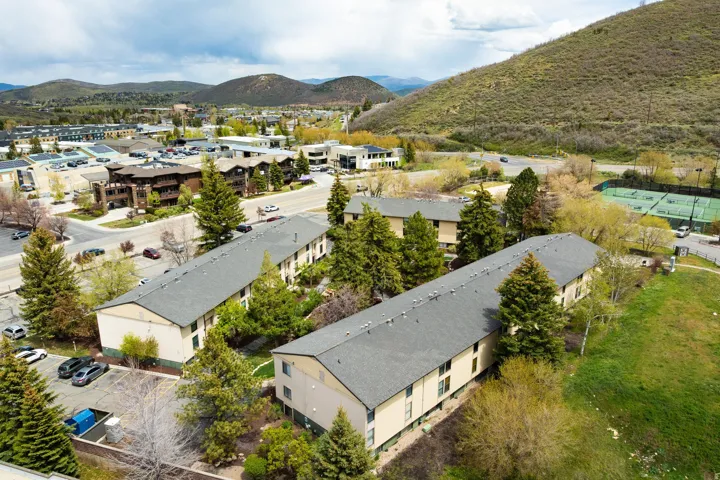Multi-unit residential structures with sloped roofs and light-colored siding