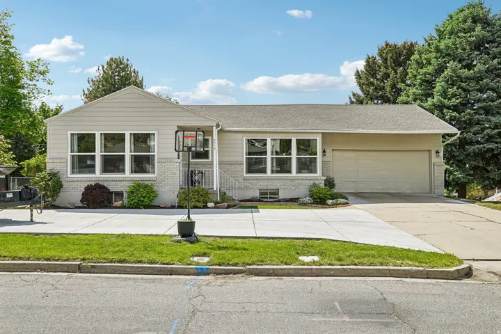 Single-story residence featuring light gray siding and a stone facade
