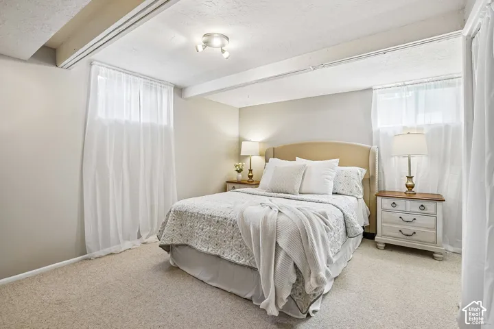 Carpeted room with exposed ceiling beams and recessed lighting