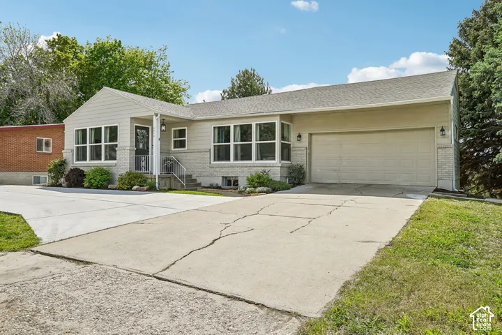Ranch-style exterior with light gray siding and a light gray brick foundation