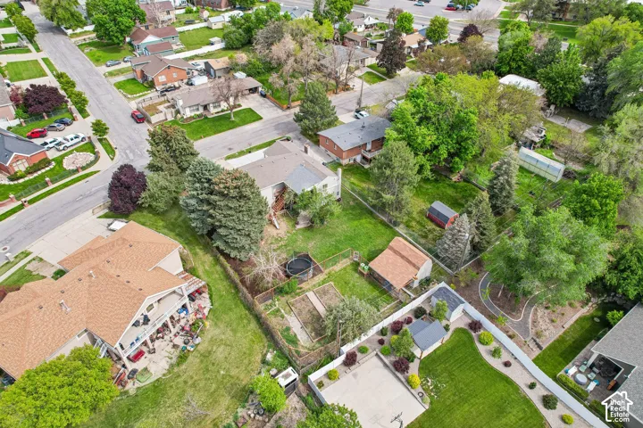 Expansive property featuring mature trees, a detached storage shed, and a fenced garden area