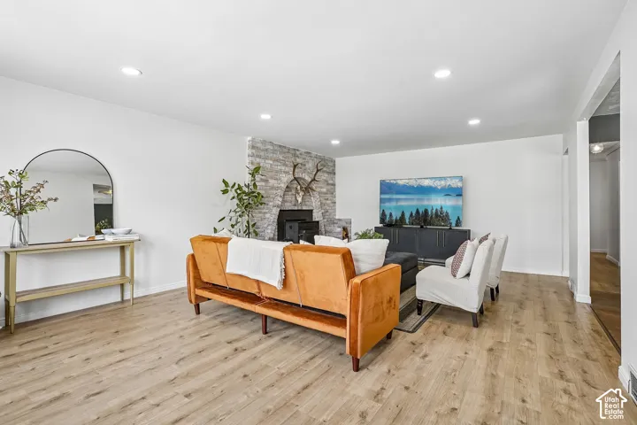 Spacious living area featuring light wood-finish flooring and recessed lighting