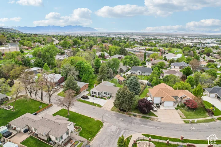 Expansive residential area featuring a diverse mix of single-family homes with mature landscaping, paved streets, and mountain scenery