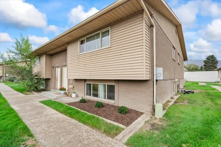 Multi-unit exterior with tan horizontal siding and brick-finish lower level
