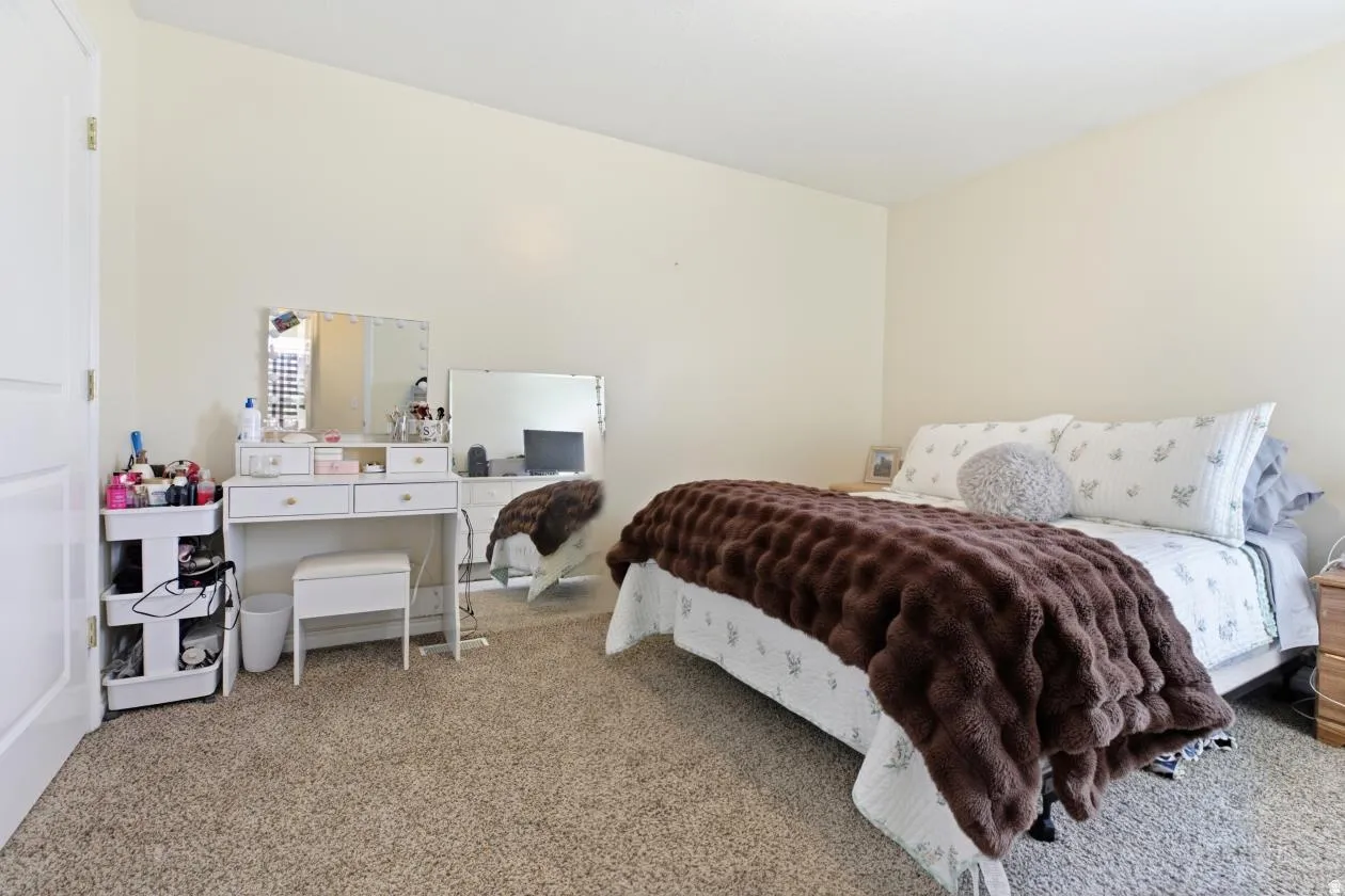 Carpeted bedroom featuring light-toned walls and a white interior door