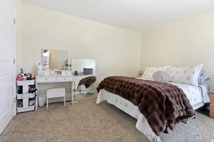 Carpeted bedroom featuring light-toned walls and a white interior door