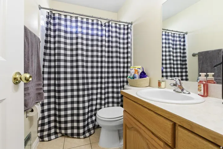 Bathroom featuring a light-toned vanity with an integrated sink and chrome faucet, a mounted mirror, and neutral-toned wall paint