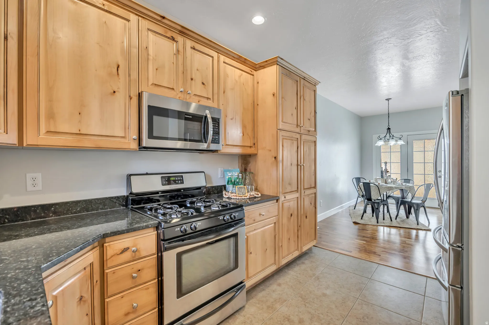 Kitchen featuring wood-finish cabinetry, dark countertops, and stainless steel appliances