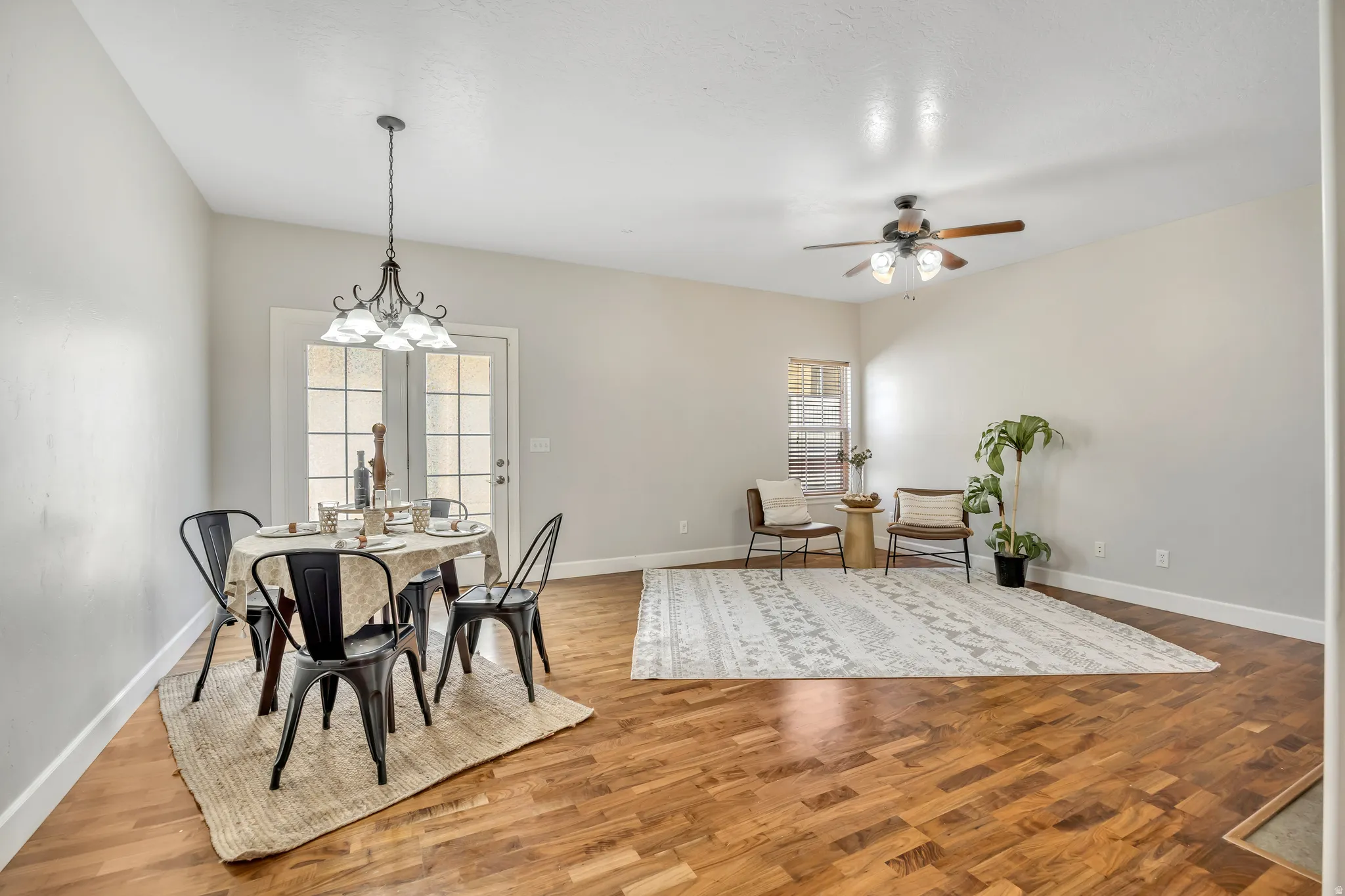 Open-concept living area featuring wood-finish flooring, a vaulted ceiling, and a ceiling fan