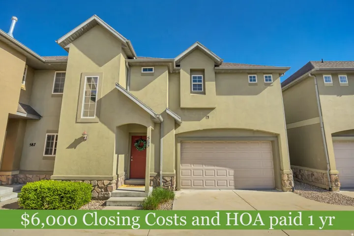 Stucco exterior with stone accents, featuring an arched entryway and a single-car garage