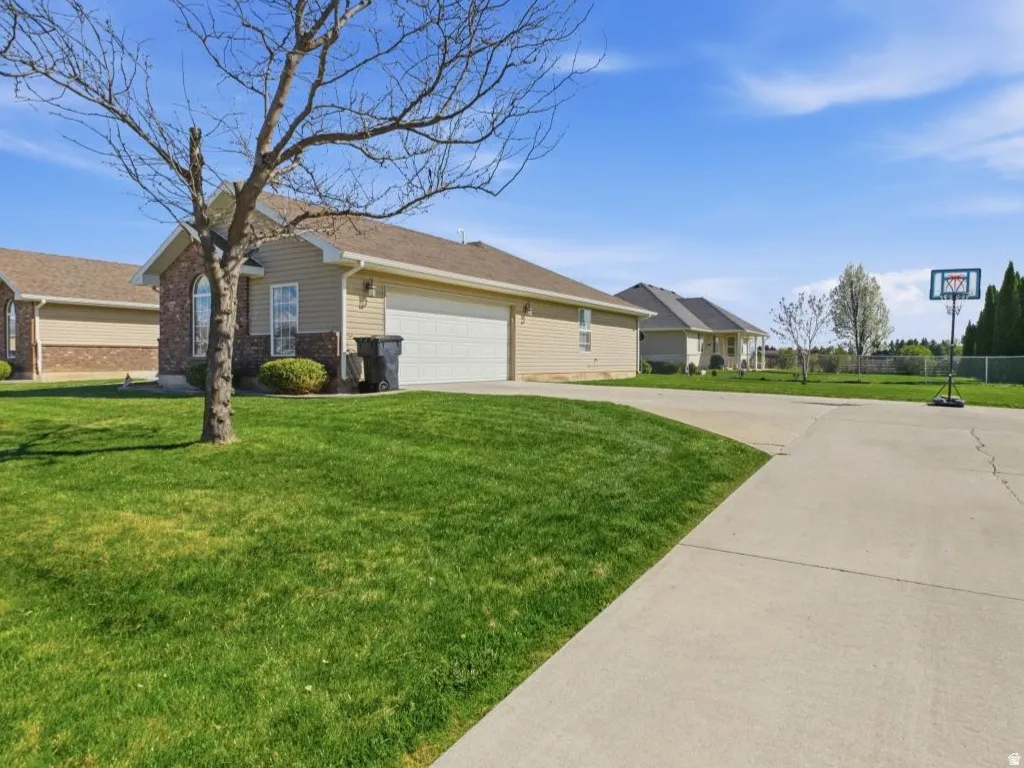 Exterior featuring a two-car garage, brick and siding facade, arched window detail, and concrete driveway
