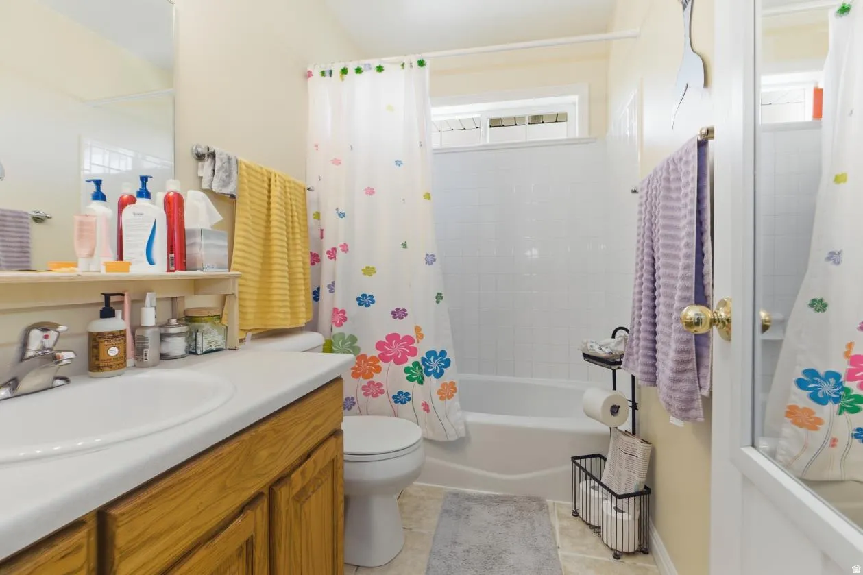 Bathroom featuring a single vanity with wood-finish cabinetry, a white countertop, and an integrated sink
