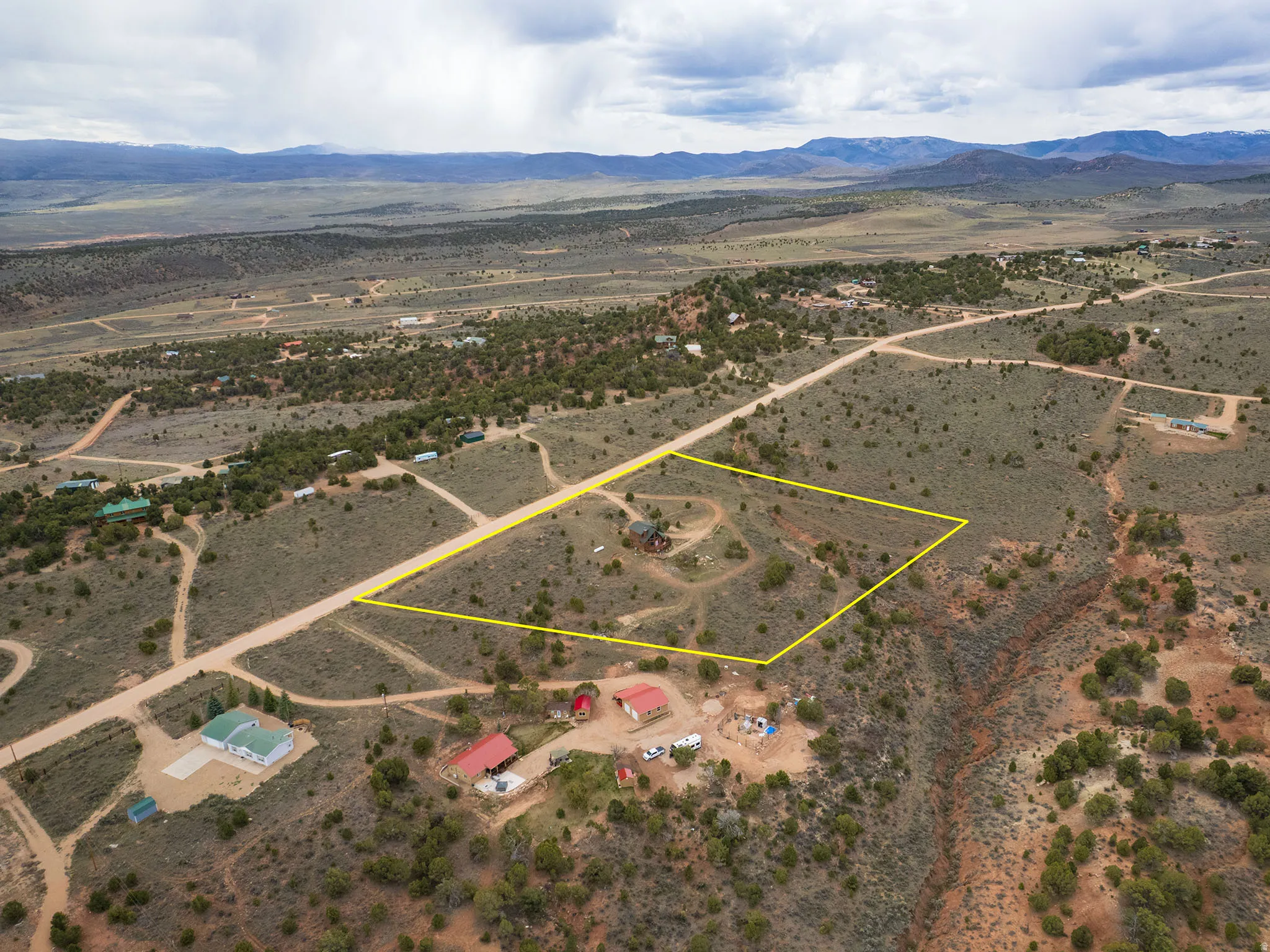 Aerial view of sparsely populated area featuring a mountain backdrop and property boundaries highlighted