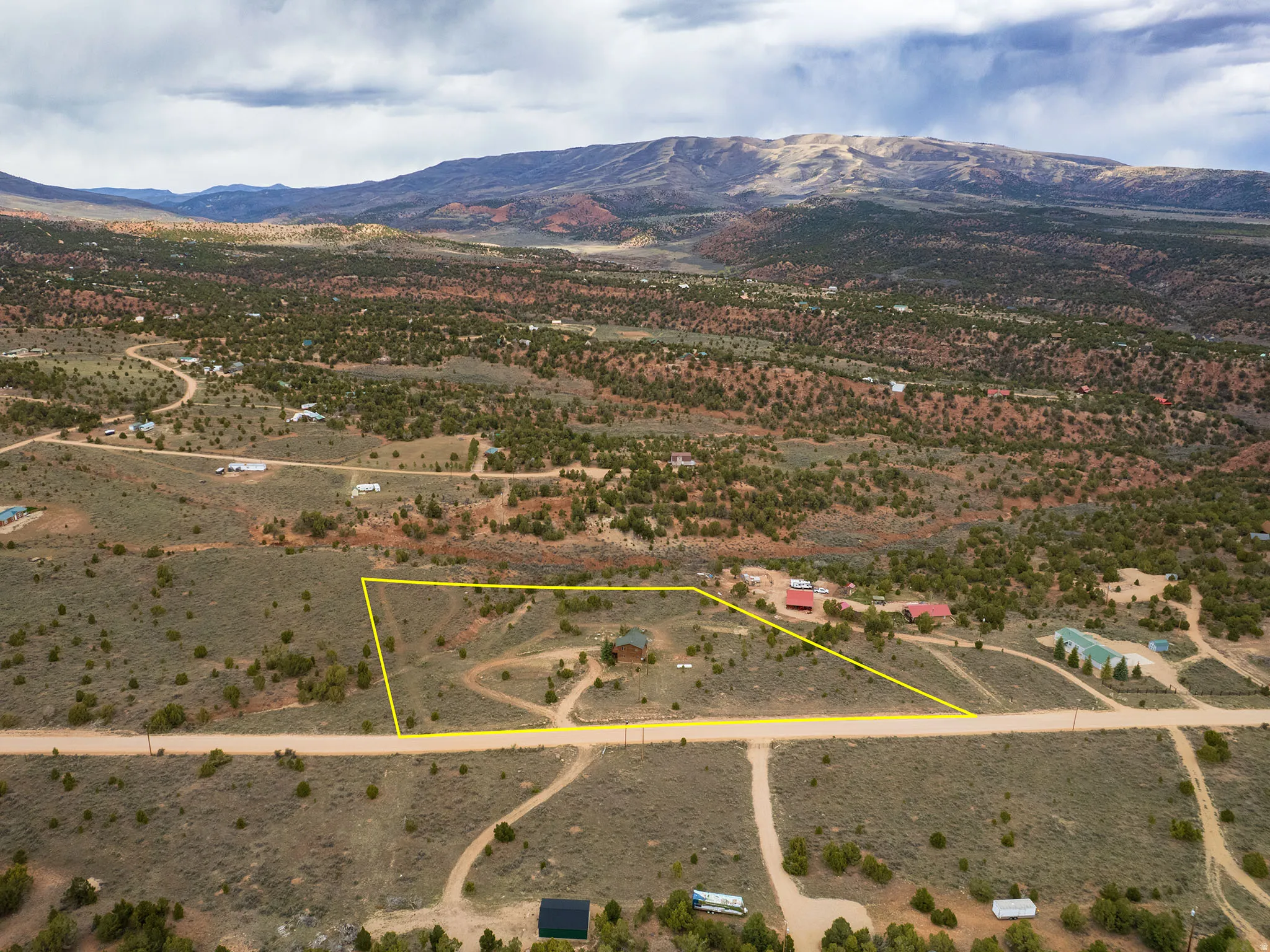 Overview of rural landscape featuring a mountainous background and property boundaries highlighted