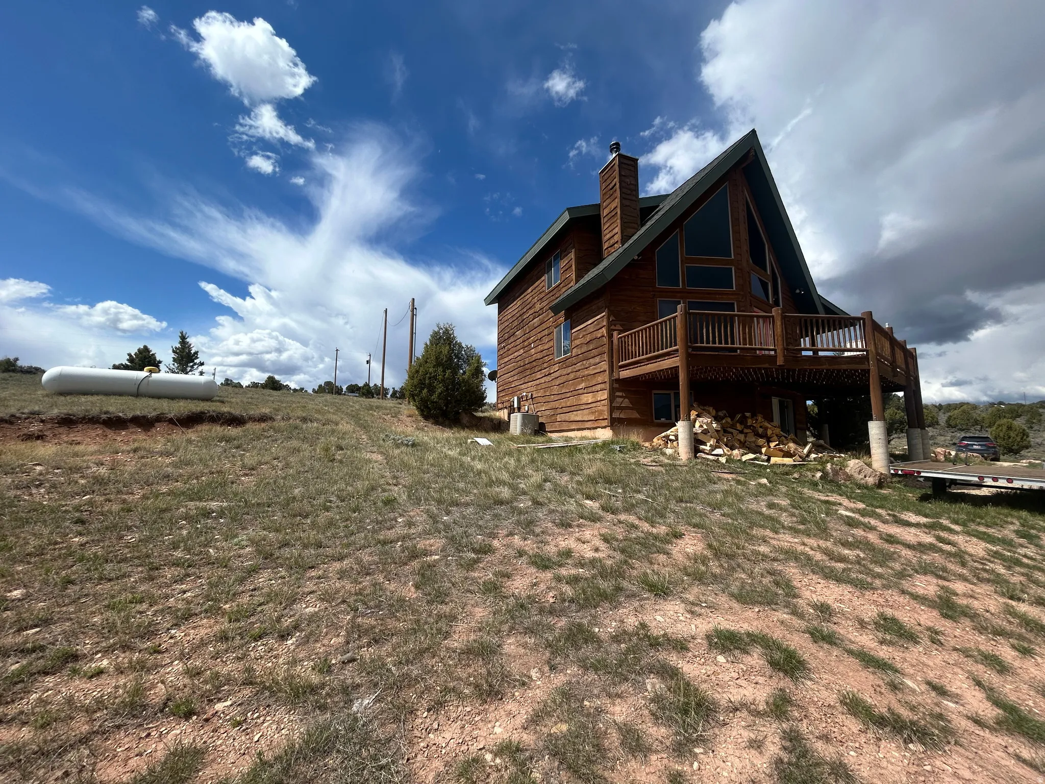 Wood-sided home with a prominent A-frame architectural style and an expansive deck