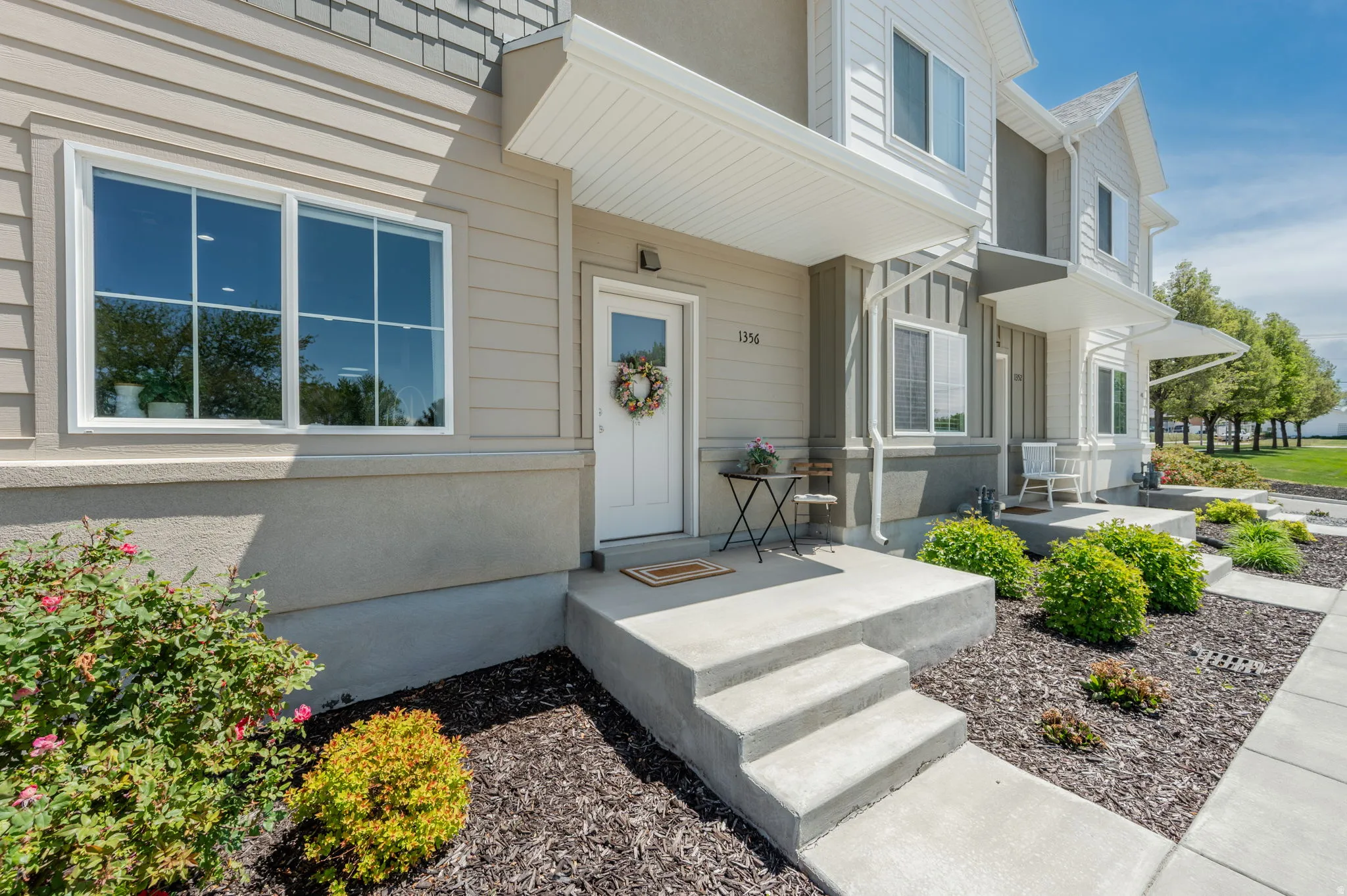 Concrete entry steps leading to a front door with an overhead awning