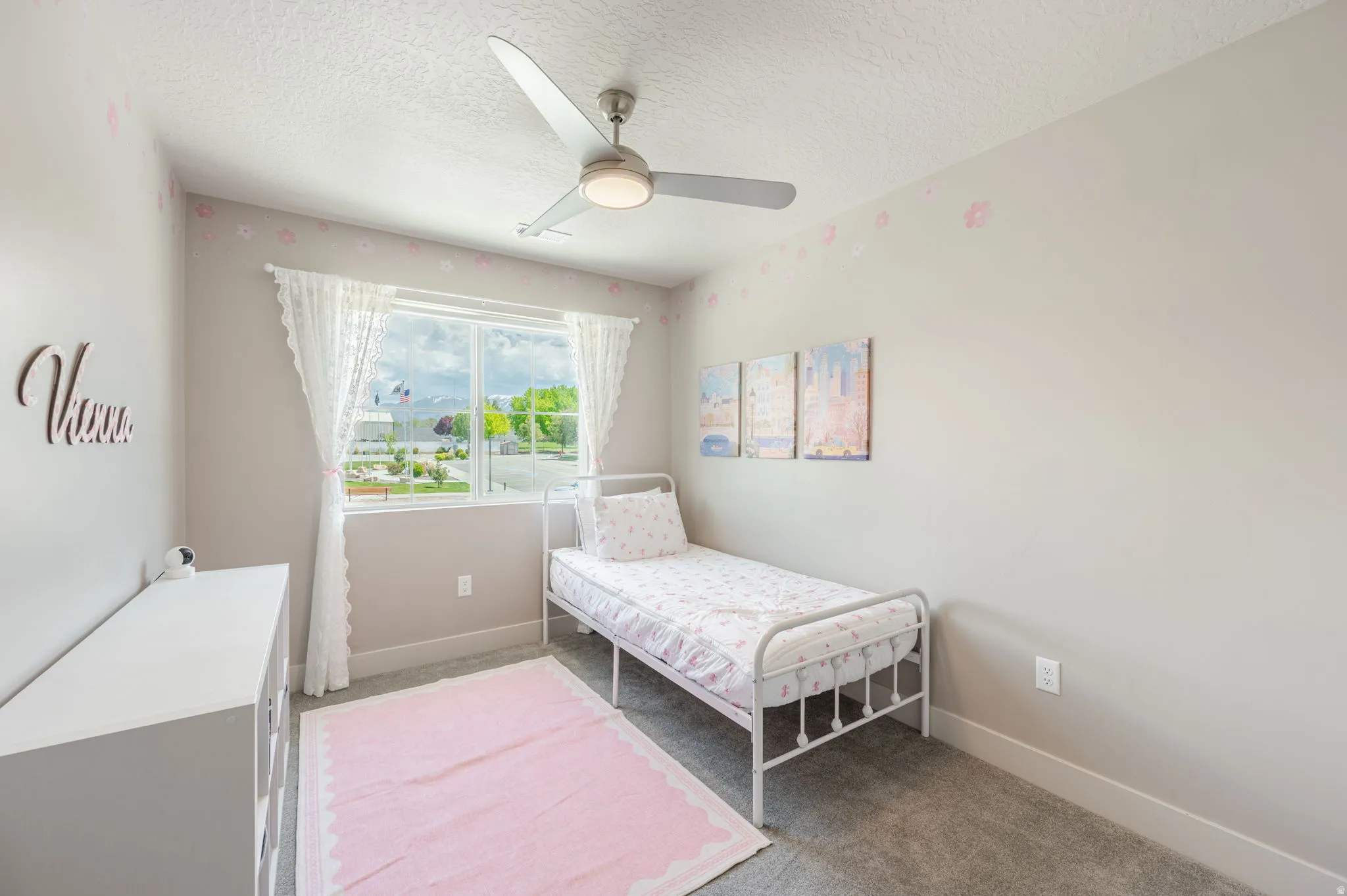 Bedroom featuring a window with exterior views, ceiling fan, and carpet flooring